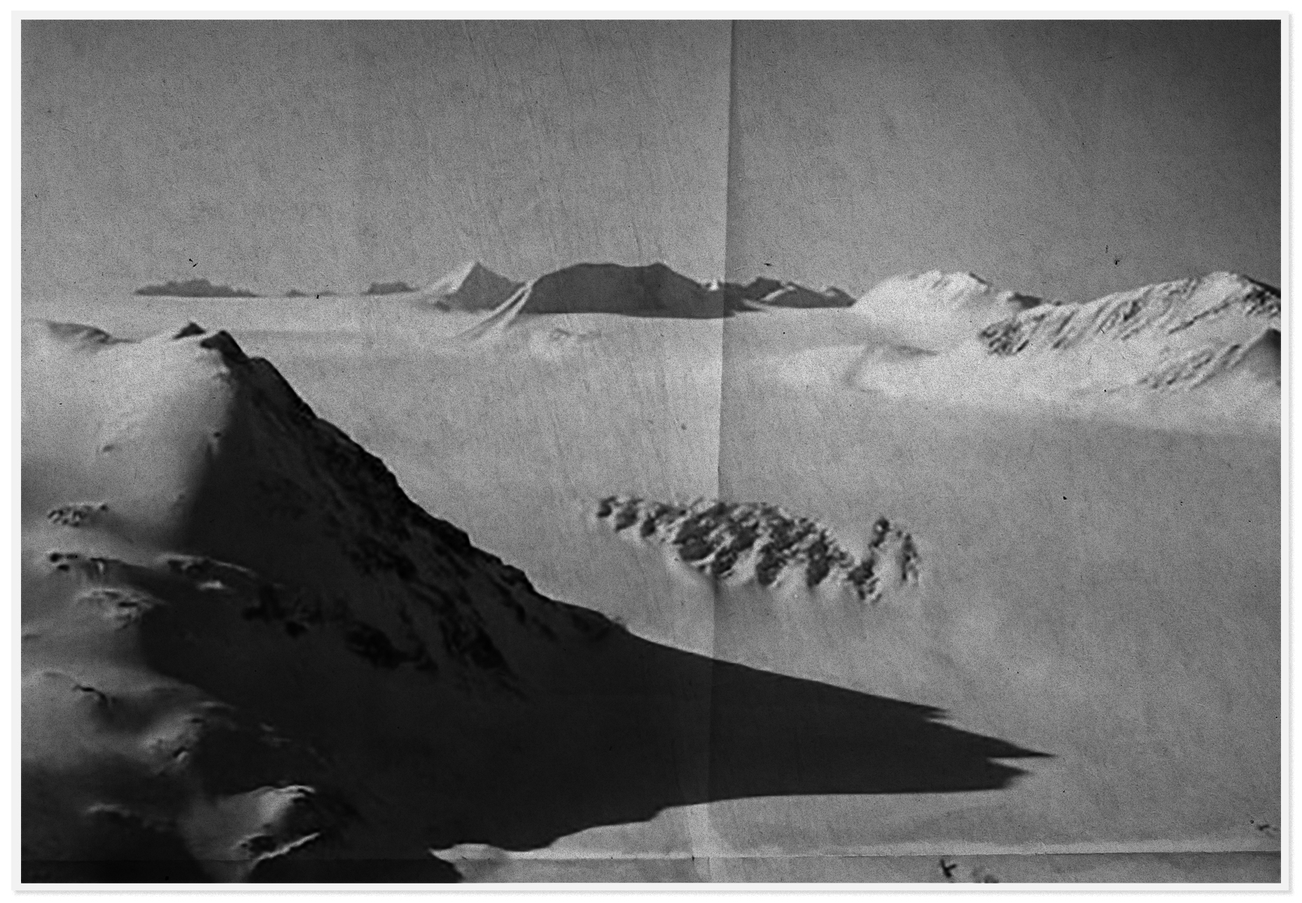 A worn, creased black and white photo of a vast, snowy tundra.